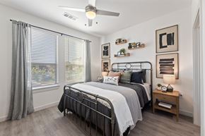 Fort Worth apartment for rent - A bedroom with a large bed and a ceiling fan.