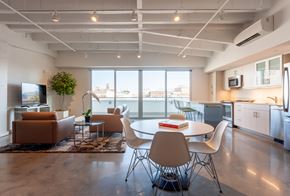 New Orleans apartment for rent - A modern open plan living and kitchen area with a table and chairs.