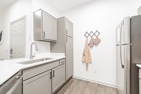 Dallas apartment for rent - a kitchen with white cabinets and stainless steel appliances and a stainless steel refrigerator