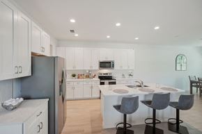 South Naples townhouse for rent - A modern kitchen with white cabinets and a central island.