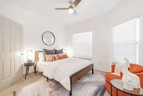 Dallas apartment for rent - a bedroom with a large bed and a ceiling fan