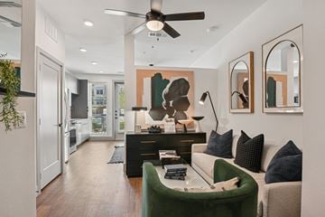 Lewisville apartment for rent - A modern living room with a green sofa and a black coffee table.