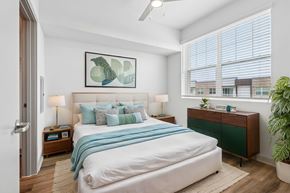 Dallas apartment for rent - A bedroom with a large bed and a ceiling fan.