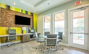 Round Rock apartment for rent - A conference room with a brick wall and a TV above the desk.