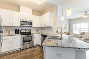Pasadena apartment for rent - A kitchen with white cabinets and a granite countertop.