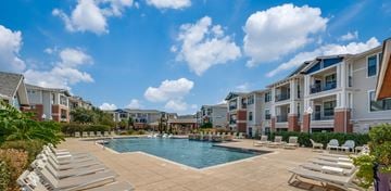 Lewisville apartment for rent - A pool surrounded by sun loungers and apartment buildings.