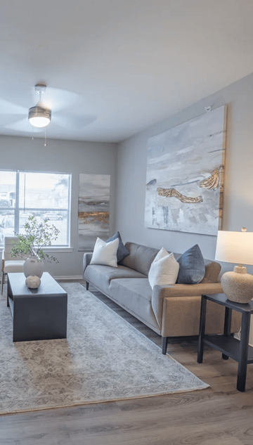 Houston apartment for rent - A living room with a grey couch, a coffee table, and a large painting on the wall.