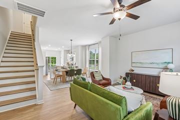 Charlotte townhouse for rent - A living room with a green couch and a staircase.