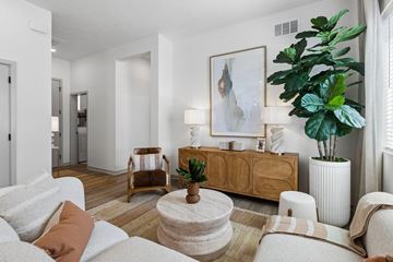 Elkhorn townhouse for rent - A living room with a white couch, a wooden side table, and a large painting on the wall.