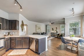 Katy apartment for rent - A modern kitchen with dark wood cabinets and a white island.