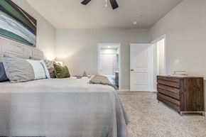 Katy apartment for rent - A bedroom with a large bed and a wooden dresser.