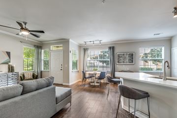 Katy apartment for rent - A living room with a grey couch and a bar area.