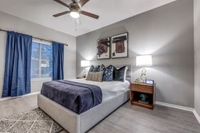Dallas apartment for rent - a bedroom with a bed and a ceiling fan