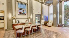 Houston apartment for rent - A dining room with a table set for four and a television mounted on the wall.