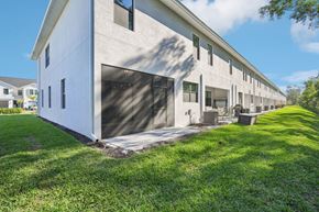 South Naples townhouse for rent - A long white building with a garage door on the side.