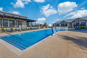 Georgetown apartment for rent - a swimming pool with chairs and a building in the background