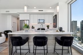 San Diego apartment for rent - A modern kitchen with a bar area and three black chairs.