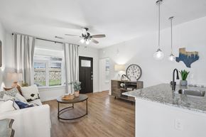 Leander apartment for rent - A modern kitchen with a marble countertop and a large island with a sink.