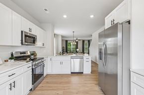 Charlotte townhouse for rent - modern kitchen with stainless steel appliances and white cabinets.
