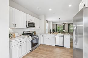 Charlotte townhouse for rent - A modern kitchen with white cabinets and stainless steel appliances.