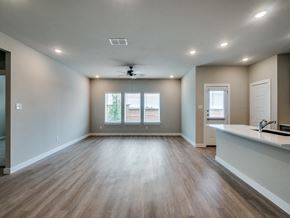 Fort Worth triplex for rent - A spacious room with wood flooring and a ceiling fan.