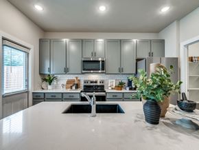 Fort Worth triplex for rent - A kitchen with a white countertop and grey cabinets.