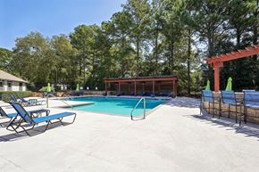 Marietta apartment for rent - A pool area with a red pergola and lounge chairs.