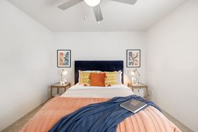 Houston apartment for rent - a bedroom with a large bed and a ceiling fan