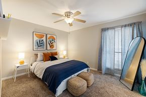 Houston apartment for rent - a bedroom with a large bed and a ceiling fan