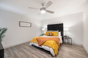Houston apartment for rent - a bedroom with a bed and a ceiling fan