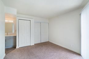 Dallas apartment for rent - a bedroom with white walls and carpet and a door to a bathroom