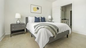 Charlotte apartment for rent - A bedroom with a bed, nightstand, and lamp.