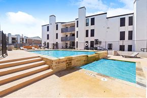 Dallas apartment for rent - a swimming pool with a building in the background