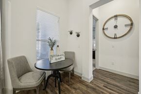 Mckinney apartment for rent - A bright front den area located directly off the main entrance, featuring soft eggshell walls and dark wood floors that lead into the rest of the apartment.