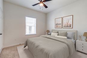 Denison apartment for rent - an expansive bedroom with a large bed and a ceiling fan