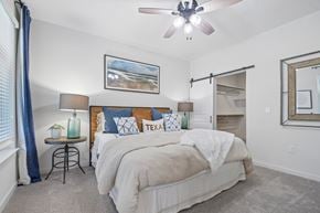 Leander townhouse for rent - A bedroom with a large bed and a ceiling fan.