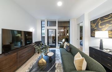 Fort Worth apartment for rent - A modern living room with a green sofa and a gold vase.