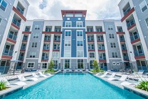 Houston apartment for rent - an apartment building with a large pool in front of it