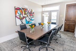 Houston apartment for rent - a conference room with a table and chairs and a painting on the wall