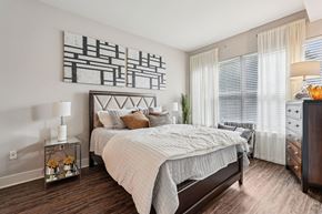 Atlanta apartment for rent - A bedroom with a large bed and a painting on the wall.