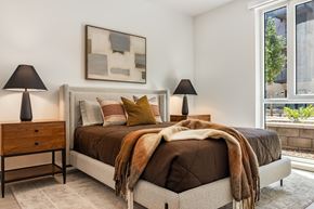 Huntsville apartment for rent - A bedroom with a bed, two lamps, and a painting on the wall.