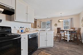 Aberdeen townhouse for rent - A kitchen with white cabinets and a black stove top oven.