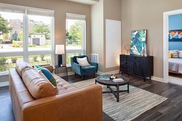 Lombard apartment for rent - A living room with a brown couch, a blue chair, and a painting on the wall.