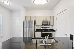 Nashville apartment for rent - A kitchen with a refrigerator, microwave, oven, and sink.