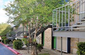 San Antonio apartment for rent - a building with a staircase and trees in front of it