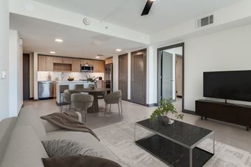 Dallas apartment for rent - A modern living room with a grey sofa and a black coffee table.
