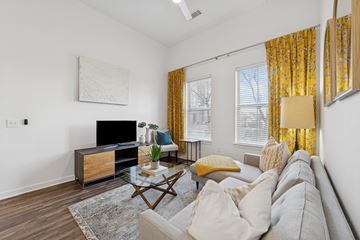 Farmers Branch apartment for rent - A living room with a grey couch, a wooden coffee table, and a painting on the wall.
