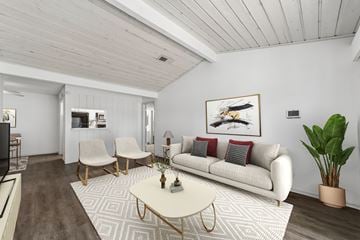 Dallas apartment for rent - A living room with a white couch, a coffee table, and a painting on the wall.
