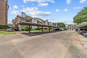 Dallas apartment for rent - A parking lot with a building in the background.