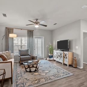 Montgomery apartment for rent - A living room with a ceiling fan, a sofa, a chair, a coffee table, a television, and a rug.